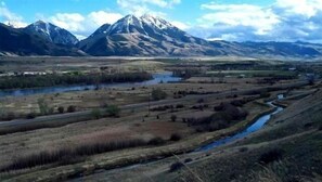 A mountainous landscape with a river and fields.