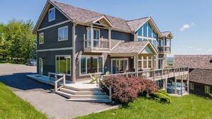 A two-story house with a balcony, a covered porch, and a driveway.