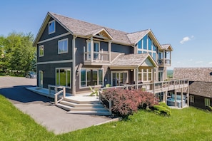 A two-story house with a balcony, a covered porch, and a driveway.