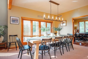A dining area with a wooden table, chairs, and a chandelier.