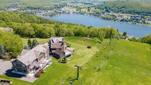 A large building with multiple floors, a ski lift, and a lake in the background.