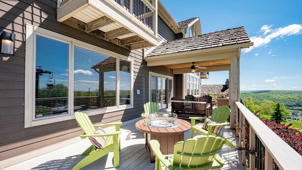 A deck with outdoor furniture, a fire pit, and a view of the landscape.