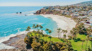 Un pueblo costero con playa, casas y palmeras.