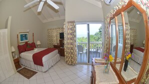 A bedroom with a bed, a mirror, a dresser, a nightstand, a window with curtains, and a balcony with a table and chairs.