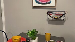 A dining table with a plant, a basket, and various dishes and utensils.