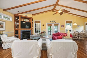 TV, fireplace, DVD player, books - Woodlands Wonder: Cute Oak Island Cottage with Private Pool Welcomes Nightly Res (Oak Island)