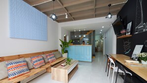 Un salon moderne avec un canapé en bois, une table basse et un coin repas comprenant une table et des chaises en bois.