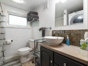 A bathroom with a toilet, sink, and a mirror above it.