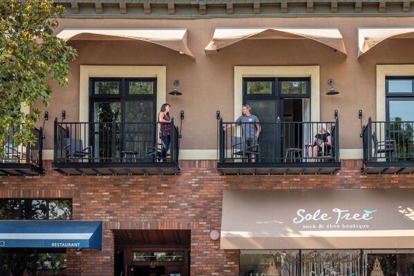 Un edificio con fachada de ladrillo, varios balcones y una tienda llamada 'Sole Tree sock & shoe boutique'.
