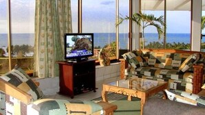 Un salon avec un téléviseur, un canapé et une table basse.