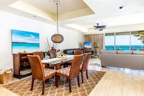 A dining area with a table, chairs, and a hanging light fixture.