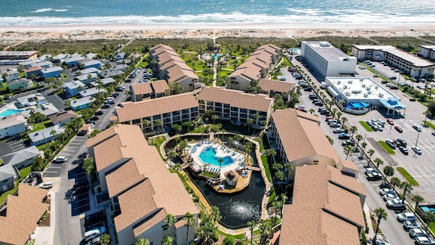 A resort with a central pool, multiple buildings, and a beach view. - Ocean Villas 108: Top floor 3 bedroom condo in gated complex - 2 pools, beach (St. Augustine Beach)