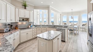 A spacious kitchen with a large island, white cabinetry, and a view of the beach. - 12 Collier Beach, Oceanfront, Pool, Great for Large Groups, Free Golf, Oceanfront (Hilton Head Island)