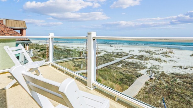 A balcony with white chairs overlooking a beach with dunes and a clear sky. - 12 Collier Beach, Oceanfront, Pool, Great for Large Groups, Free Golf, Oceanfront (Hilton Head Island)