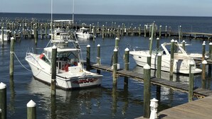 A marina with multiple boats docked at wooden piers. - Luxury Beachfront Home with Extra Large Deck;  Sleeps up to 20! (Gulf Shores)