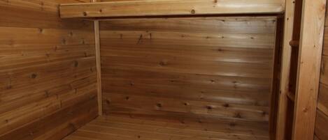 Una sauna de madera con bancos y techo inclinado.