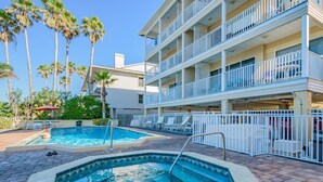 A hotel with a pool area, multiple balconies, and palm trees. - 2-Story Beach-side Complex with Direct Beach Access, Book Your Beach Getaway! (Indian Rocks Beach)