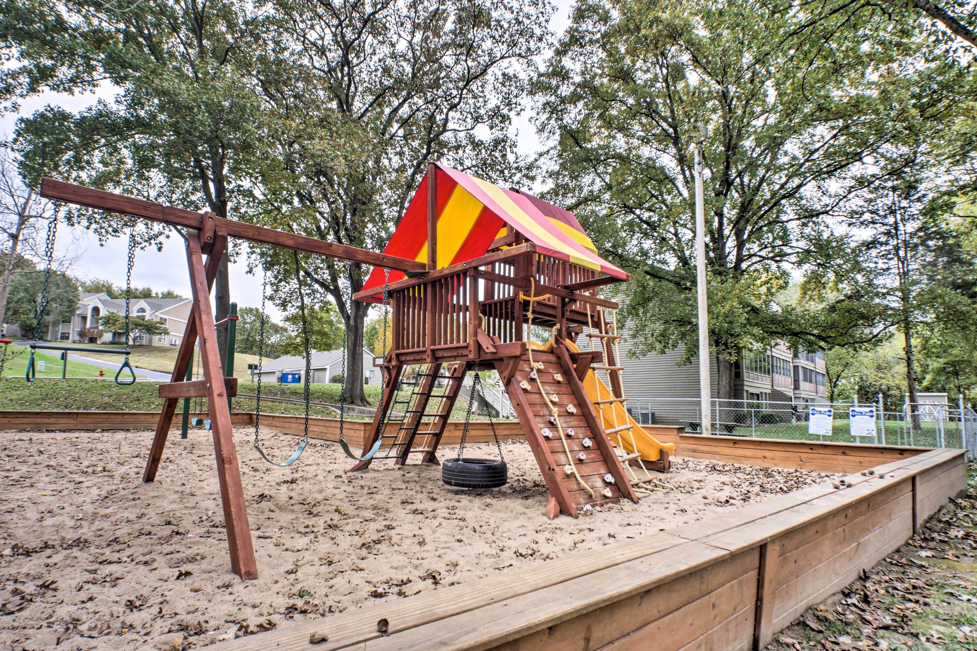 A playground with a swing set, a slide, and a climbing structure.