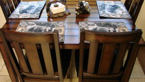 A dining table with four chairs, each with a placemat featuring a bear design. - Two Bedroom One Bath Apartment(sleeps no more than 4) (Mariposa)