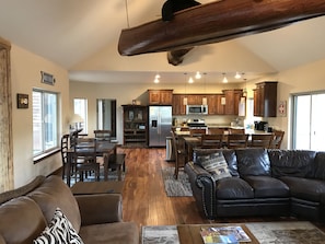 Relax in a spacious living area with a modern kitchen, featuring a large sofa, armchairs, and a coffee table.