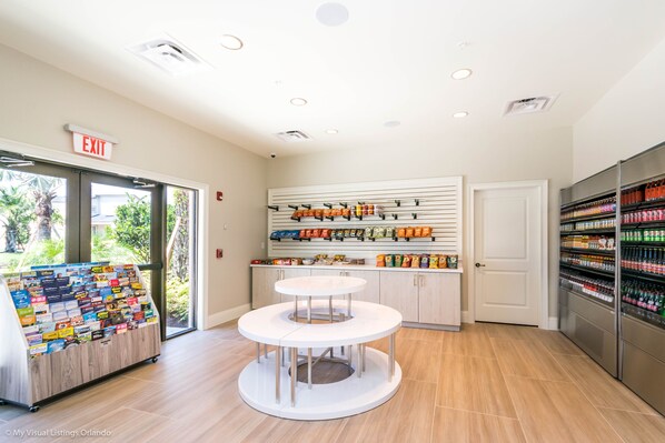 A clean, well-lit store with an exit sign, a display of snacks, and a refrigerated section. - Beautiful Townhome w/Splash Pool! *great location across from clubhouse* (Kissimmee)