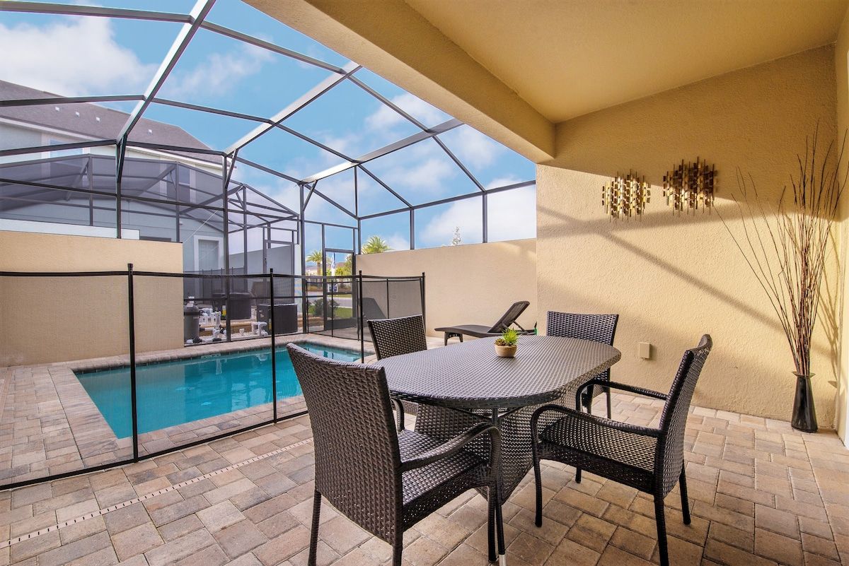 A covered patio with a pool, outdoor furniture, and a view of the surrounding area.
