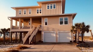 Ein zweistöckiges Haus mit Balkon, Treppe und Garage.