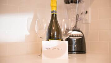 A bottle of champagne with a "Welcome!" sign in a kitchen setting.