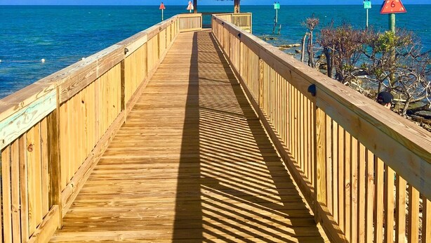 A wooden pier leading to a thatched-roof structure by the sea. - Ocean Front 2/2 Condo,OCEAN FRONT/MARINA VIEW,Tavernier/Key Largo Fl. Fla.Keys (Tavernier)