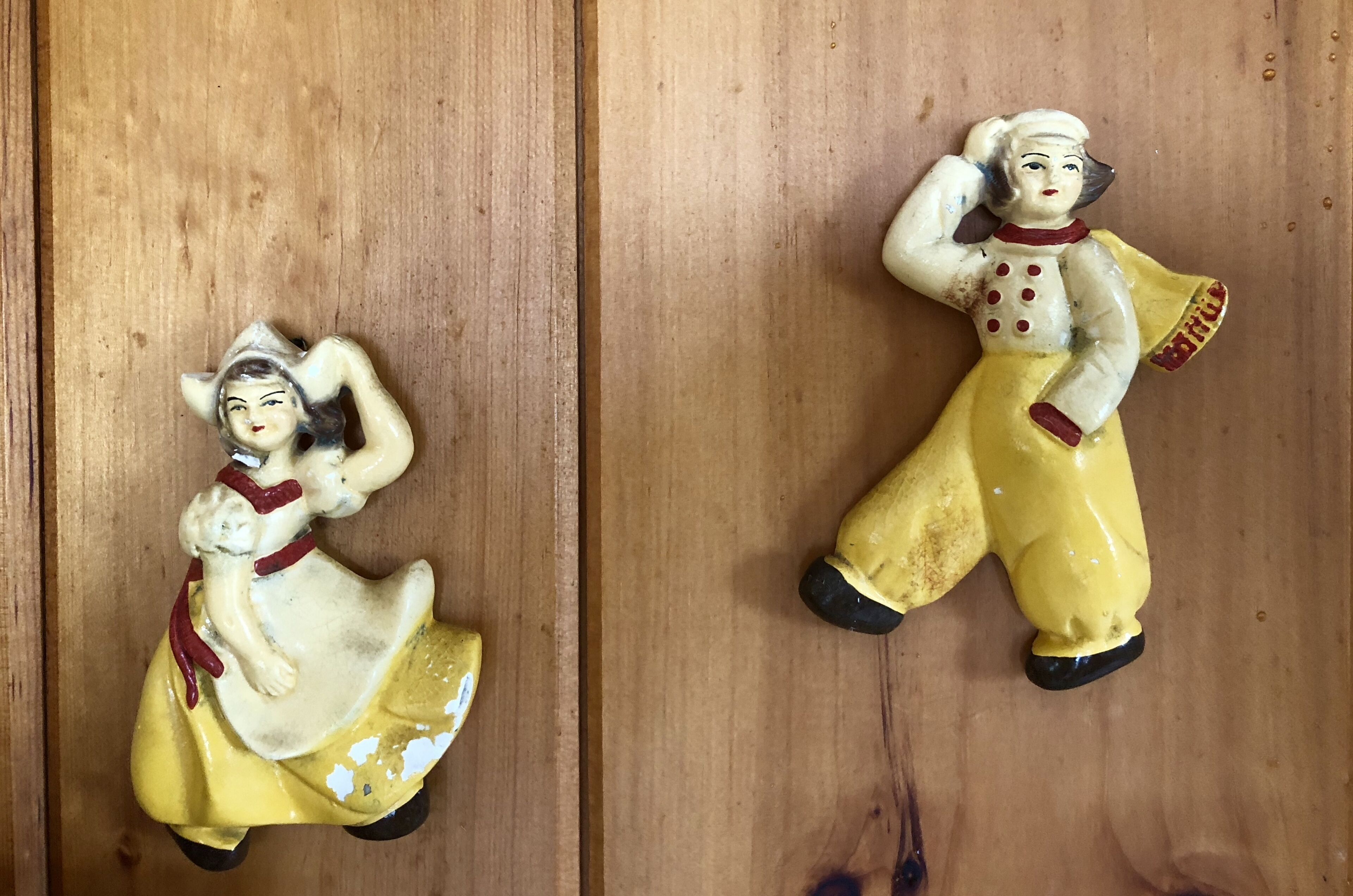 Due figurine in ceramica su un piano di legno.