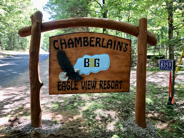 A wooden sign for Chamberlain's Eagle View Resort with a bird logo and the BSG logo.