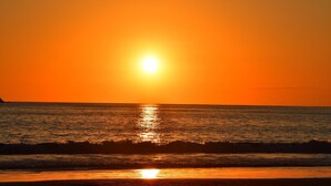 Tramonto sull'oceano con le onde che riflettono la luce del sole.
