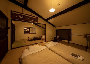 Una habitación tradicional japonesa con suelo de tatami, techo bajo y puerta corredera.