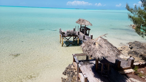 A wooden pier with a thatched roof seating area and a small table, overlooking clear turquoise waters. - ONE OF A KIND PROPERTY! Breathtaking Views, Ocean Breezes, Huge Dock, Peaceful (Georgetown)