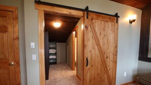 A room with a wooden sliding door, carpeted floor, and a ceiling light. - Ski or Ride, Hike Or Bike This Is Your Paradise! (Breckenridge)