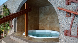 A spa area with a hot tub, stone walls, and wooden steps. - Ski or Ride, Hike Or Bike This Is Your Paradise! (Breckenridge)