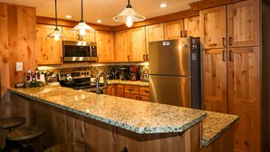 A kitchen with wooden cabinets, stainless steel appliances, granite countertops, and pendant lighting. - Ski or Ride, Hike Or Bike This Is Your Paradise! (Breckenridge)