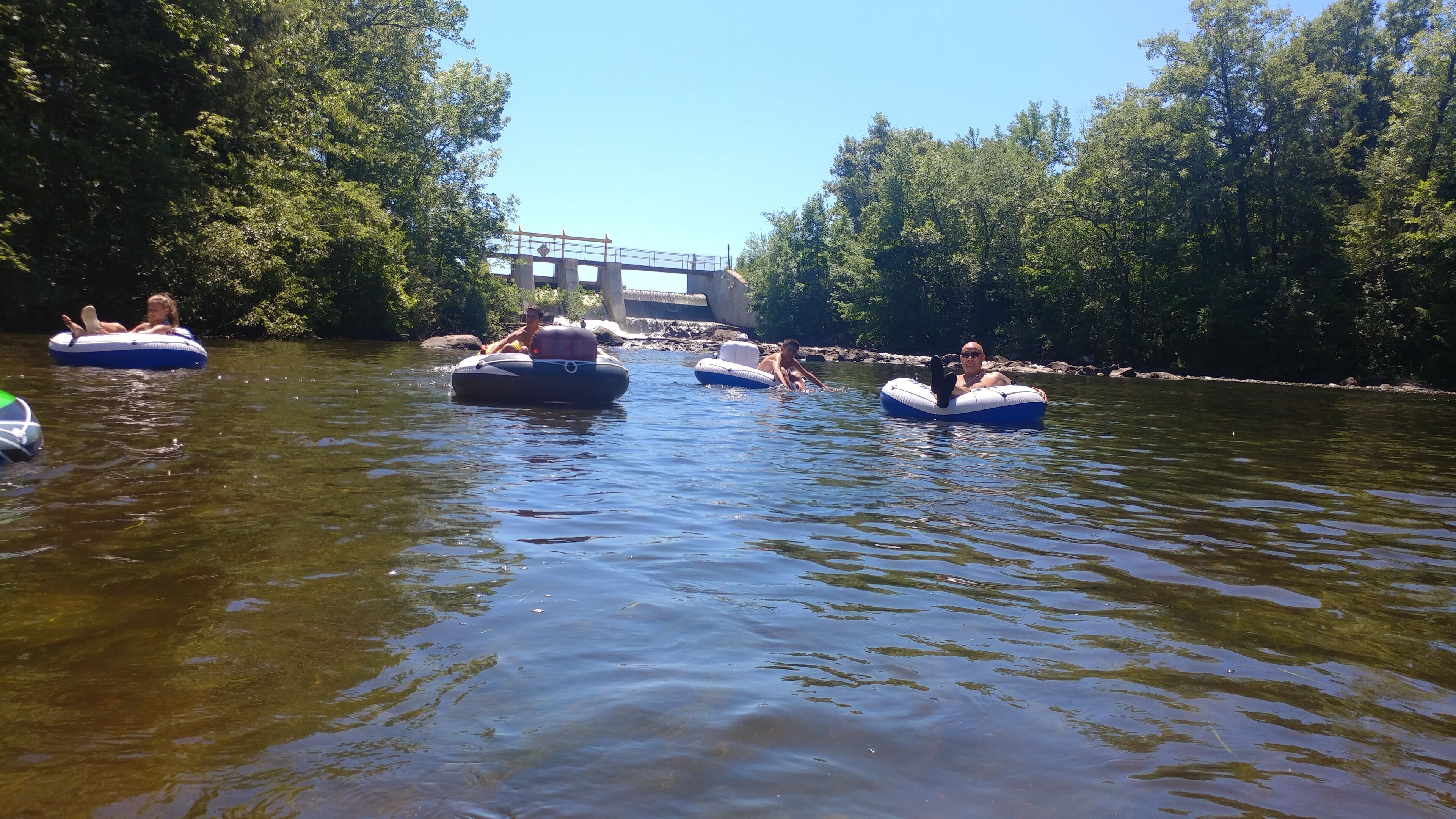 A river with people floating on inflatable rafts.