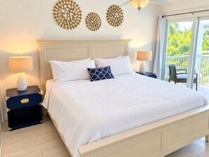 Une chambre à coucher avec un lit, deux tables de chevet et des éléments de décoration murale.