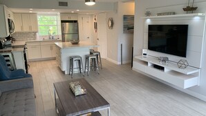 A modern kitchen with white cabinets, a stainless steel refrigerator, and a central island with stools. - Beautiful Updated Kawama Townhouse.  Marina, boat ramp, lagoon and pools. (Key Largo)
