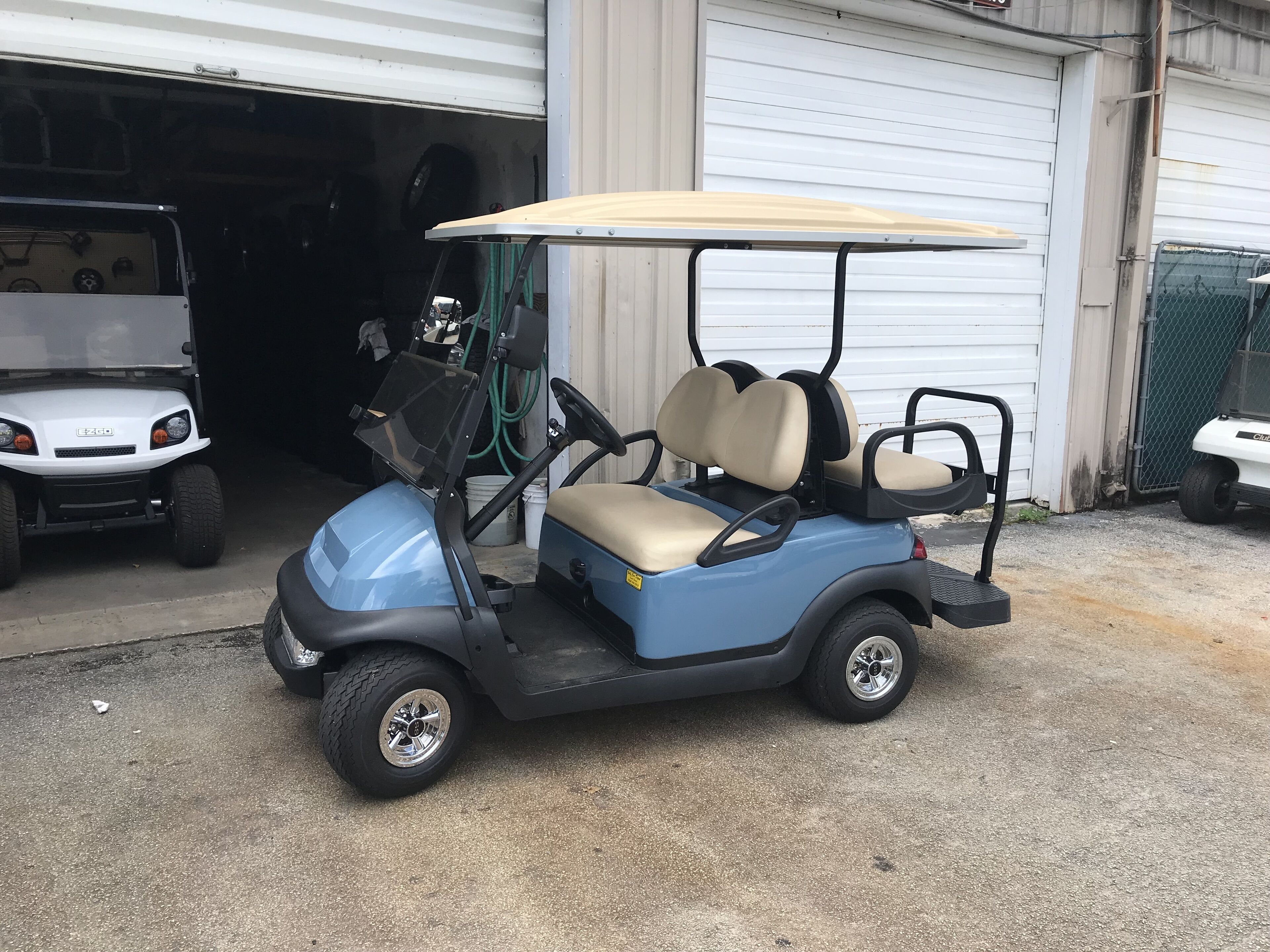 Un carrito de golf estacionado frente a un garaje.