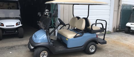 Un carrito de golf estacionado frente a un garaje.
