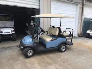 A golf cart parked in front of a garage.