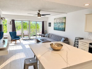 A modern living room with a sofa, a coffee table, and a dining area with a white marble island. - Beautiful Updated Kawama Townhouse.  Marina, boat ramp, lagoon and pools. (Key Largo)