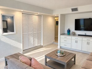Un salon moderne avec un canapé, une table basse et un téléviseur posé sur un meuble.