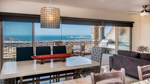 A dining area with a view of the sea, a grill, and a sofa. - Spectacular View and Luxury Condo - Pet Friendly - Weekly & Monthly discounts  (Cabo San Lucas)
