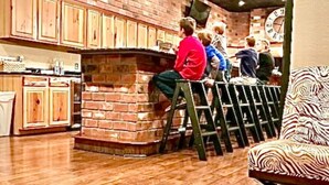 A restaurant interior with brick walls, wooden cabinets, and a wooden floor. - Historic FireHouse Lodge Very Cool! (COTTER)