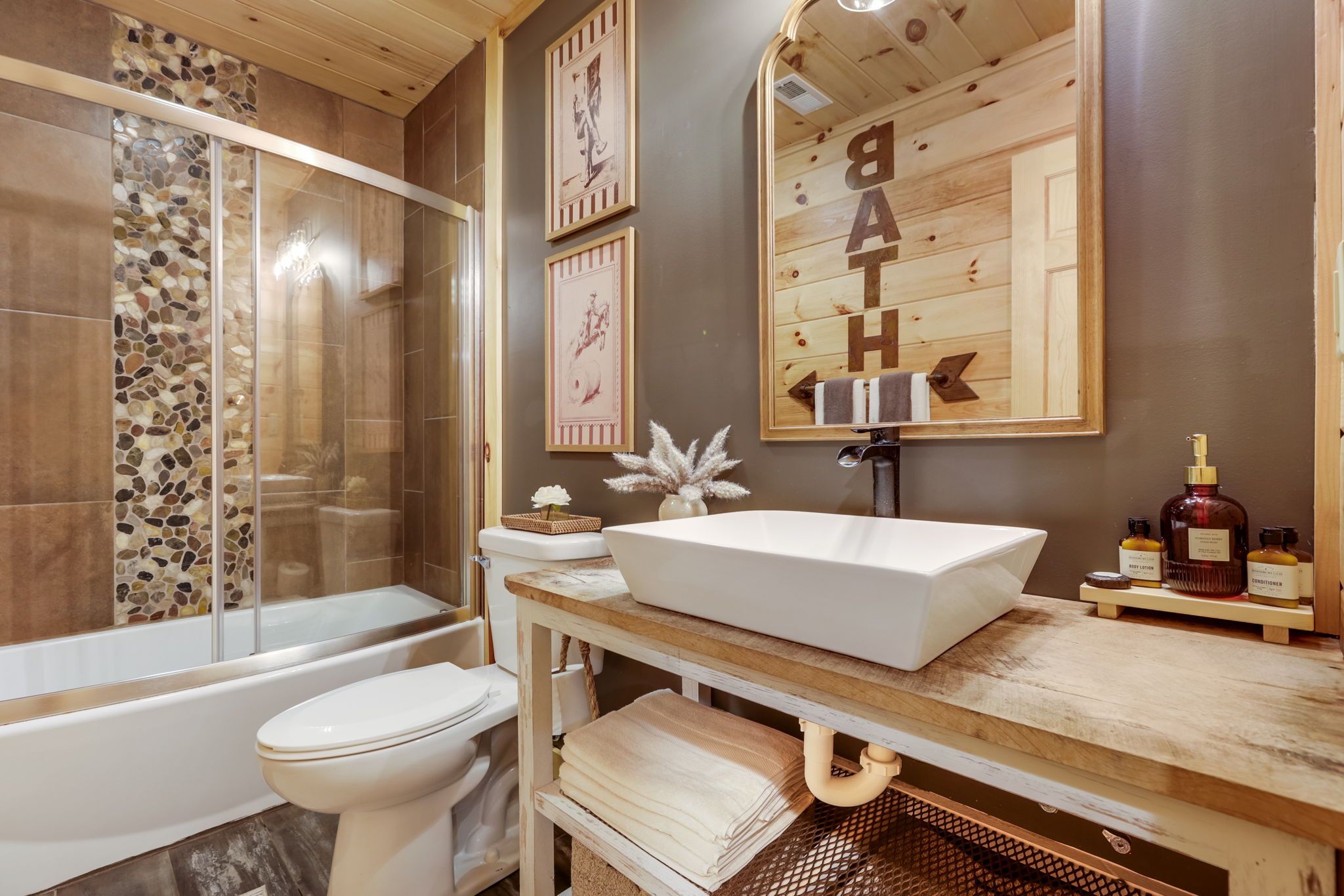 Un bagno con vasca, WC e un mobile lavabo con lavandino e articoli da toilette.
