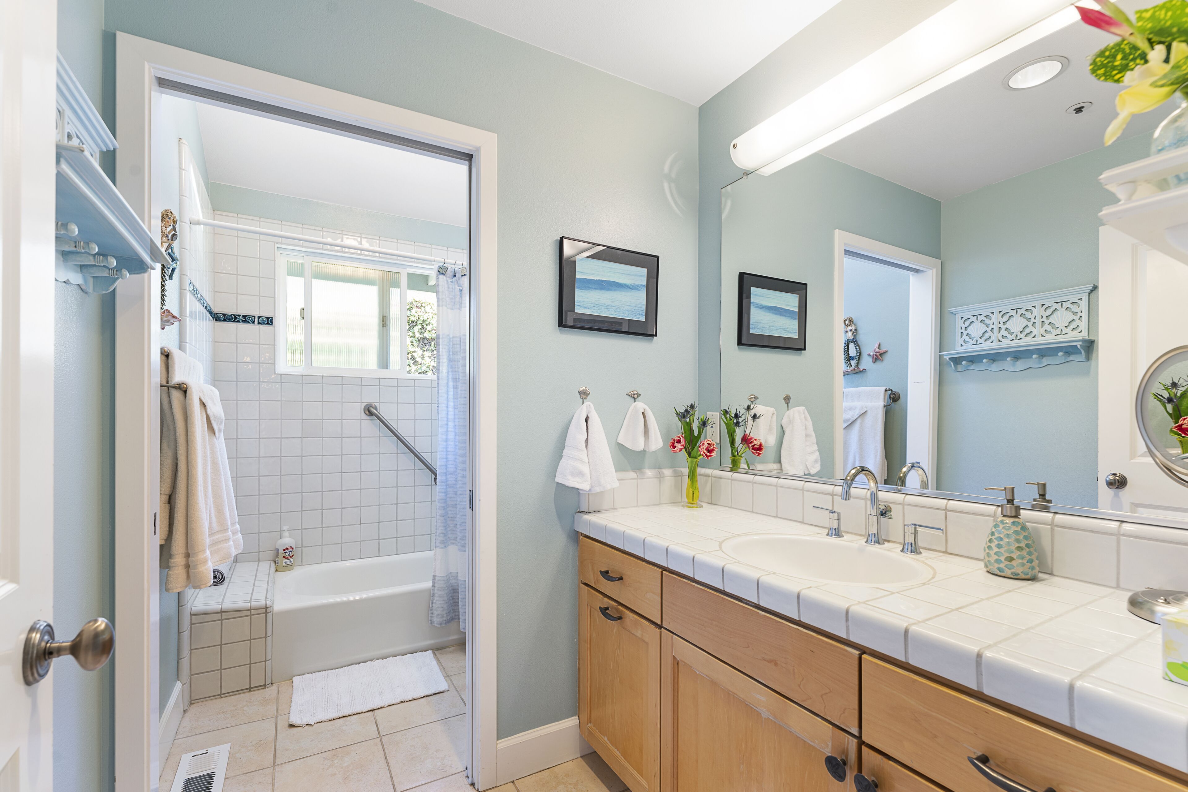 A bathroom with a bathtub, a sink, and a vanity with drawers.