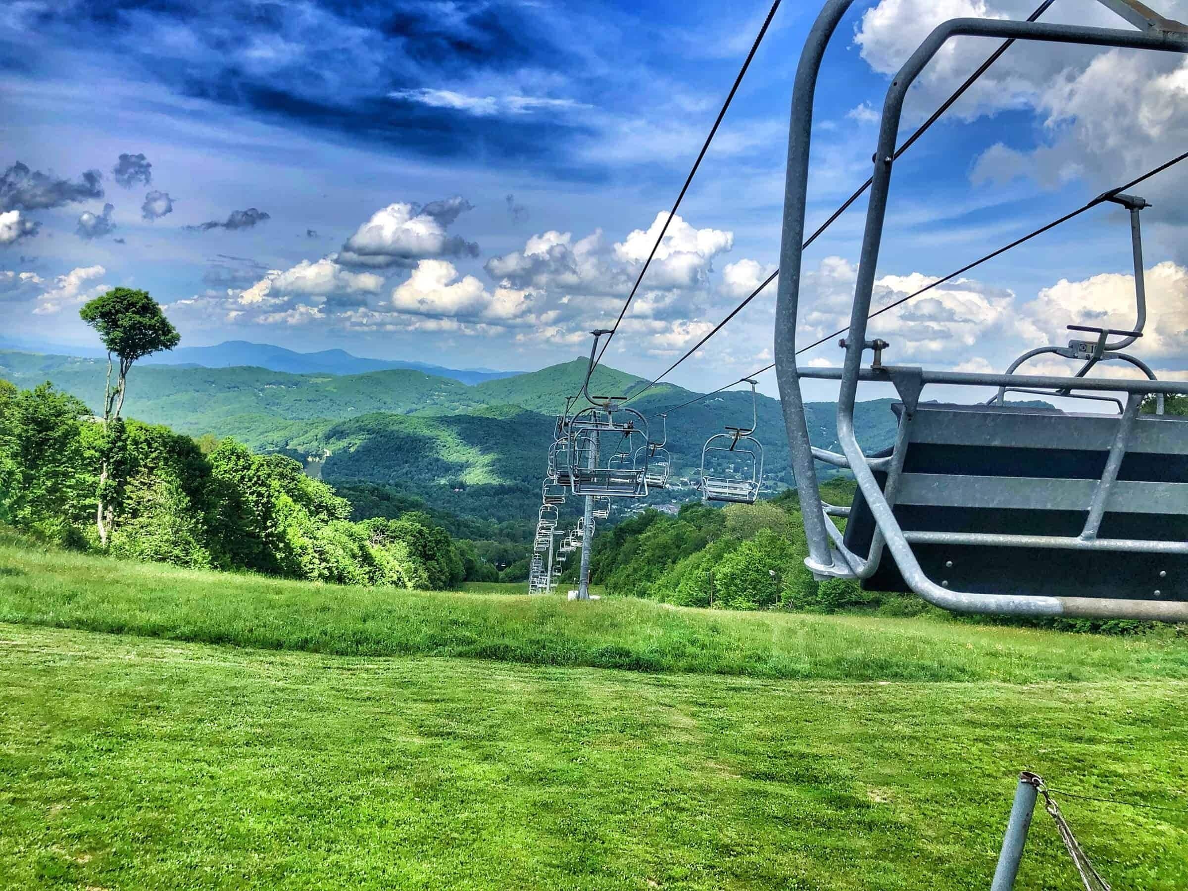 Um sistema de teleférico com uma paisagem montanhosa ao fundo.